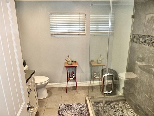 bathroom featuring tile patterned flooring, vanity, toilet, and a shower with door