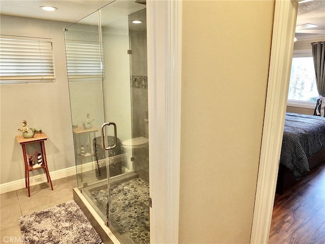 bathroom featuring hardwood / wood-style floors, toilet, and an enclosed shower