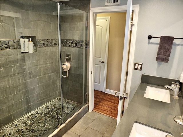 bathroom with hardwood / wood-style floors, vanity, and an enclosed shower