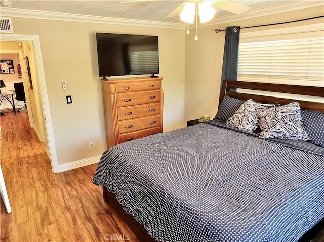 bedroom with crown molding, ceiling fan, and hardwood / wood-style flooring