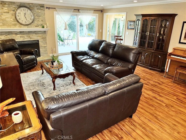 living room featuring light hardwood / wood-style floors, ornamental molding, and a fireplace