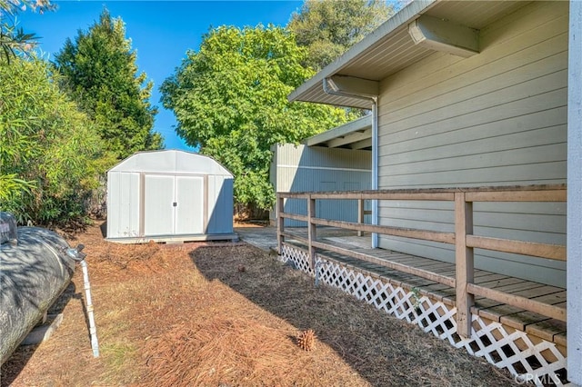 view of yard featuring a wooden deck and a shed