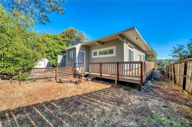 rear view of house with central AC unit, a shed, and a wooden deck