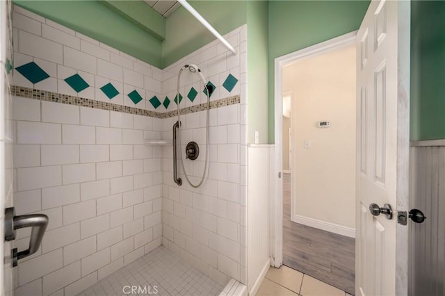 bathroom with tiled shower and hardwood / wood-style flooring