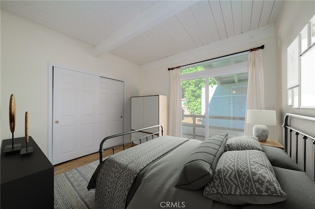 bedroom featuring wood-type flooring, wood ceiling, a closet, and beam ceiling