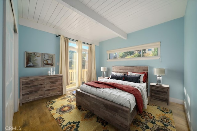 bedroom featuring hardwood / wood-style flooring, beam ceiling, and multiple windows