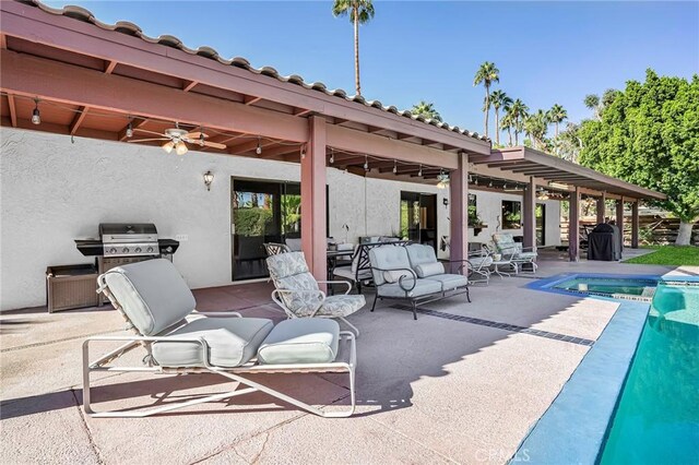 view of patio with ceiling fan, a swimming pool with hot tub, and grilling area