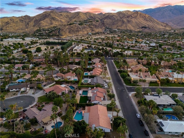 aerial view at dusk featuring a mountain view