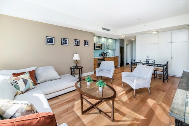 living room with light hardwood / wood-style floors and sink