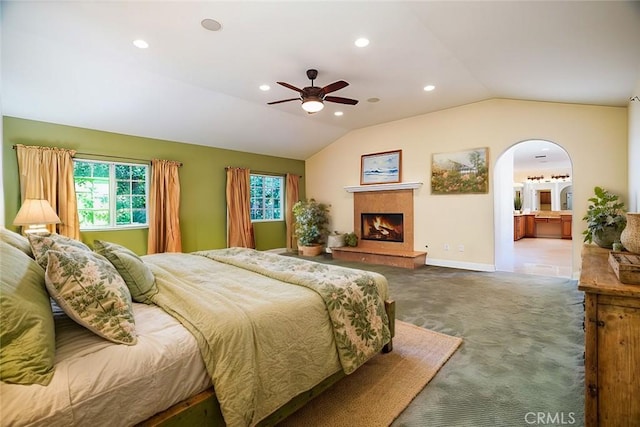 bedroom with ceiling fan, carpet floors, ensuite bathroom, and vaulted ceiling