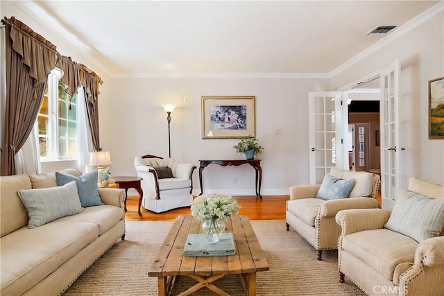 living room with french doors, light hardwood / wood-style flooring, and ornamental molding