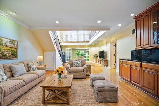 living room featuring ornamental molding and light wood-type flooring