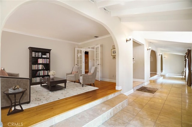 living area featuring beamed ceiling, french doors, ornamental molding, and light hardwood / wood-style flooring