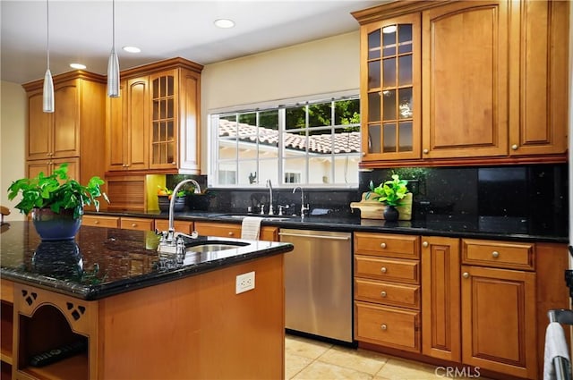 kitchen featuring decorative backsplash, stainless steel dishwasher, dark stone counters, sink, and an island with sink