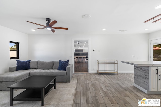 living room with plenty of natural light, light hardwood / wood-style floors, and ceiling fan