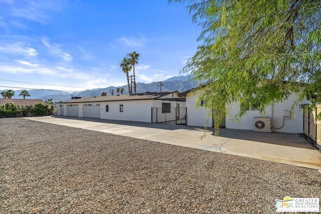 rear view of property featuring a mountain view and ac unit