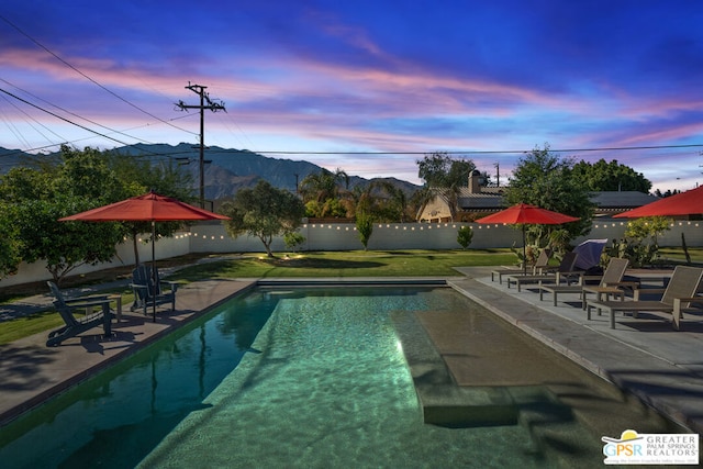 pool at dusk with a mountain view and a patio