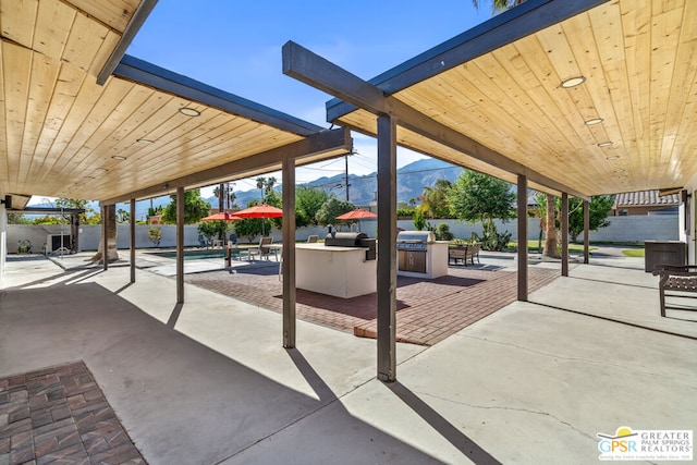 exterior space with a patio area, a mountain view, and an outdoor kitchen