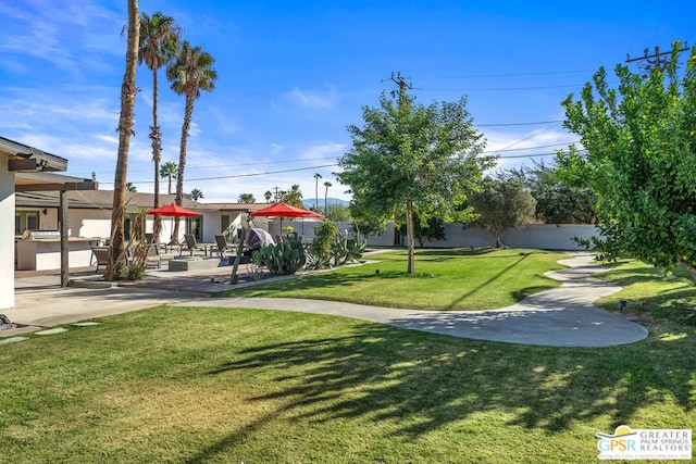 view of home's community featuring a lawn and a patio area