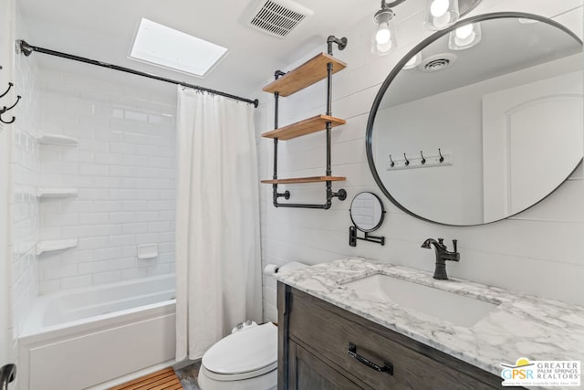 full bathroom with a skylight, vanity, shower / bath combo, and toilet