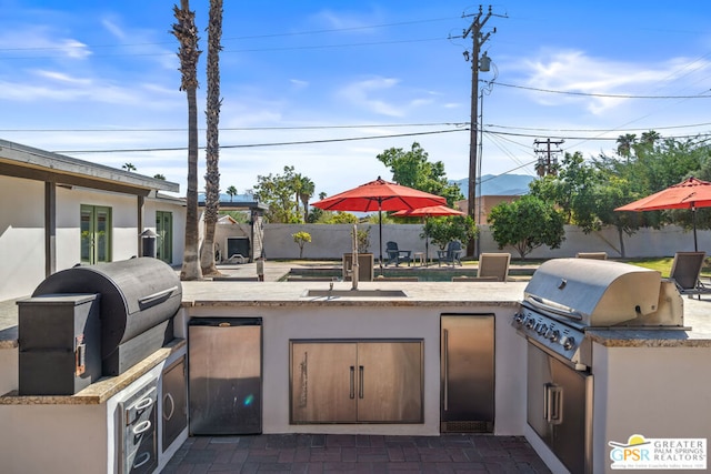 view of patio / terrace featuring a grill, exterior kitchen, and sink