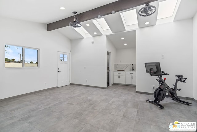 workout room with a skylight, high vaulted ceiling, and sink