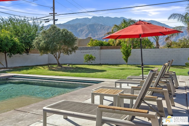 view of pool featuring a lawn, a patio area, and a mountain view