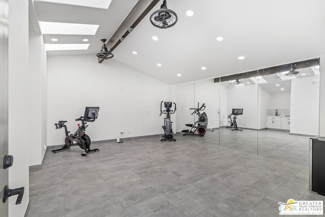 exercise area featuring vaulted ceiling with skylight