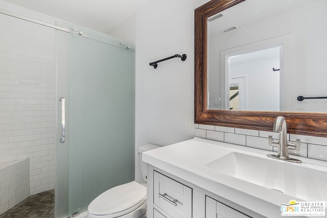 bathroom with a shower, vanity, and toilet