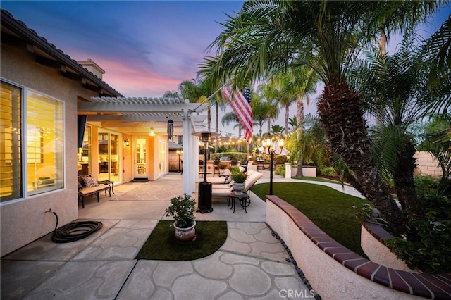 patio terrace at dusk with a pergola and an outdoor hangout area