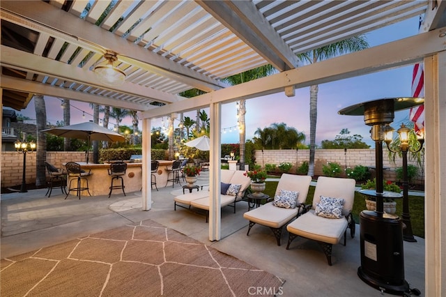 patio terrace at dusk with a pergola and a bar