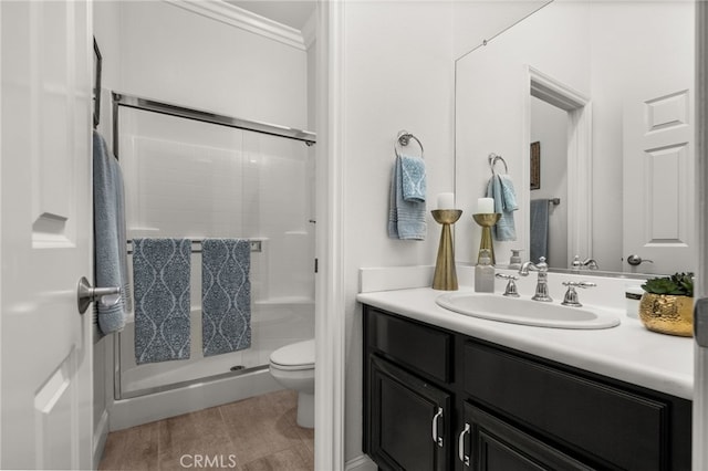 bathroom featuring vanity, wood-type flooring, an enclosed shower, and toilet