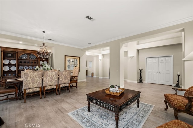 living room featuring ornamental molding, light hardwood / wood-style floors, and a notable chandelier