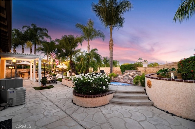 patio terrace at dusk with a pergola, cooling unit, and an outdoor bar