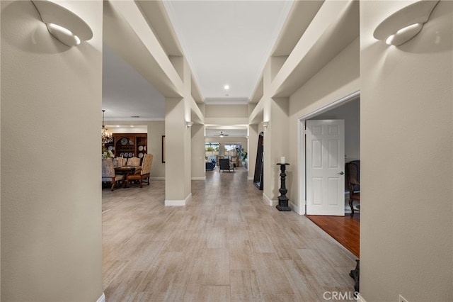 hall with light hardwood / wood-style floors and an inviting chandelier