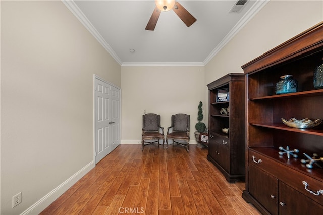 home office featuring ceiling fan, light wood-type flooring, and ornamental molding