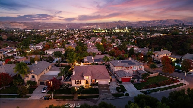 aerial view at dusk featuring a mountain view