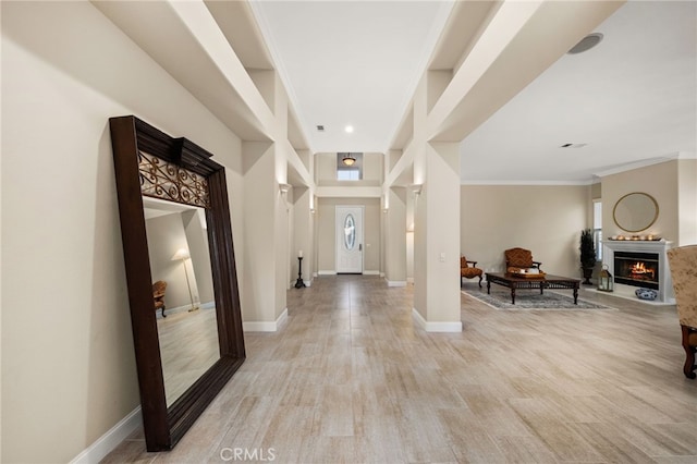 foyer featuring light wood-type flooring and ornamental molding