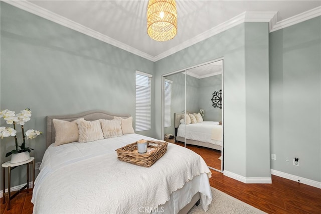 bedroom with hardwood / wood-style floors, crown molding, and a closet