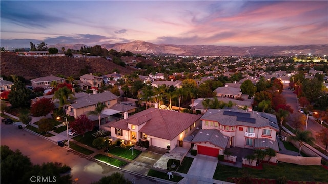 aerial view at dusk featuring a mountain view