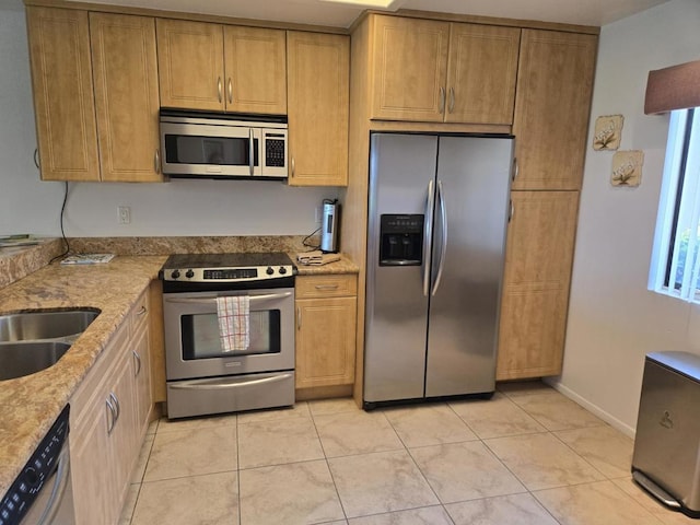 kitchen with light stone countertops, appliances with stainless steel finishes, light tile patterned floors, and sink