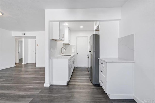 kitchen featuring white cabinets, stainless steel refrigerator, dark wood-type flooring, and sink