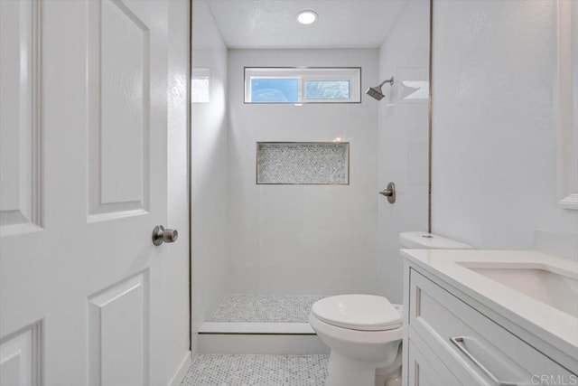 bathroom with tile patterned floors, vanity, toilet, and a shower