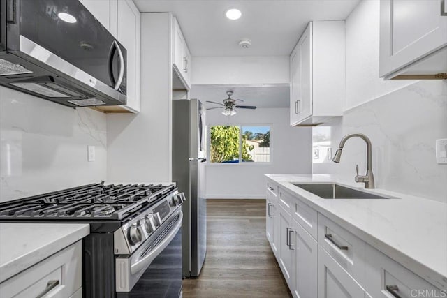 kitchen featuring white cabinets, sink, ceiling fan, dark hardwood / wood-style flooring, and stainless steel appliances