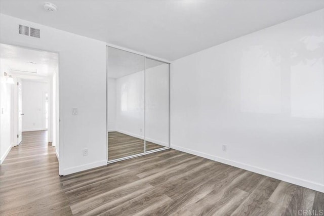 unfurnished bedroom with a closet and hardwood / wood-style flooring