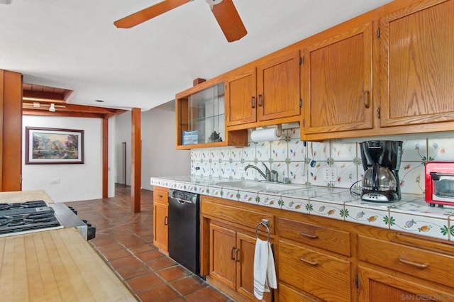 kitchen featuring tasteful backsplash, black dishwasher, sink, dark tile patterned flooring, and ceiling fan