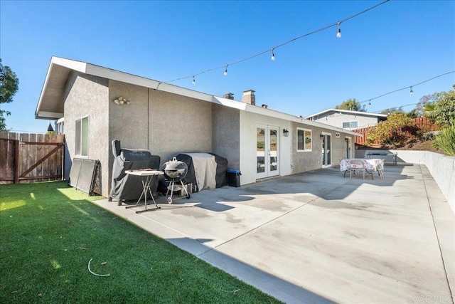 rear view of house with a yard, a patio, and french doors