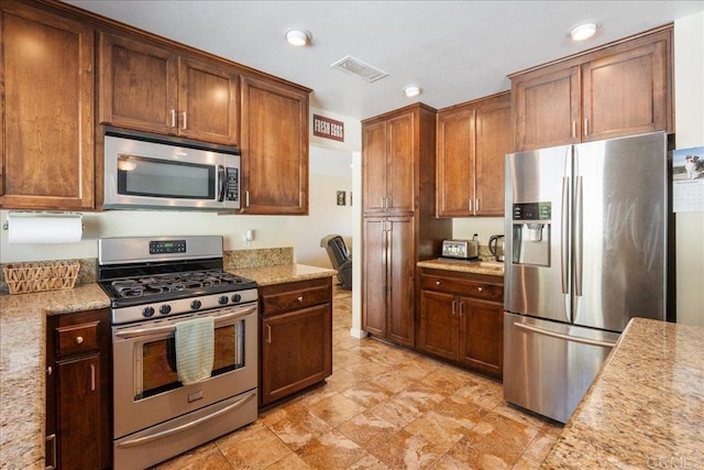 kitchen featuring light stone counters and stainless steel appliances