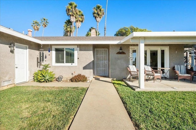 property entrance with a lawn