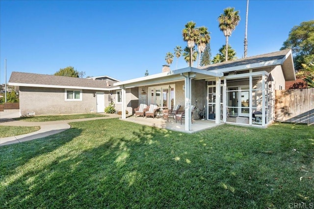 rear view of property featuring a lawn and a patio